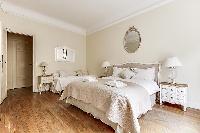 bedroom  with queen-sized bed, varying duvet colors and room wall decals in a 4-bedroom Paris luxury