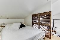 cozy bedroom with double bed at the mezzanine in a Paris luxury apartment