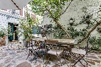 relaxing courtyard with table and chairs, and potted plants in a Paris luxury apartment