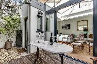 terrace with outdoor furniture, a marble-top coffee table, two stools, and a reclining chair in a Pa