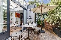 two beach recliners and an outdoor umbrella in a Paris luxury apartment