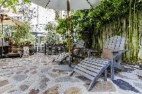 relaxing courtyard with table and chairs, and potted plants in a Paris luxury apartment