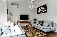 spacious living room with modern décor, cozy sofas, and a lounge seat in a Paris luxury apartment