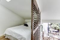 cozy bedroom with double bed at the mezzanine in a Paris luxury apartment