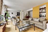 dining area highlighted by a glass table with 4 matching seats in a Paris luxury apartment