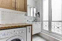 full bathroom with a washing machine, dryer, and double sink in a Paris luxury apartment