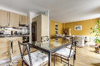 dining area highlighted by a glass table with 4 matching seats in a Paris luxury apartment