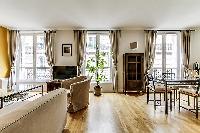 dining area highlighted by a glass table with 4 matching seats in a Paris luxury apartment