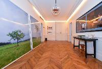 hallway with parquet floor and work of arts hanged on the wall in a 3-bedroom paris luxury apartment