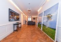 hallway with parquet floor and work of arts hanged on the wall in a 3-bedroom paris luxury apartment