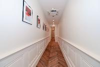 hallway with parquet floor and work of arts hanged on the wall in a 5-bedroom paris luxury apartment