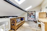 a separate sitting area with comfortable sofa chairs, books and a stereo in a 4-bedroom Paris luxury