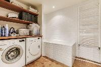 spacious well-maintained and neat bathroom with bathtub and washier and dryer in a 4-bedroom Paris l