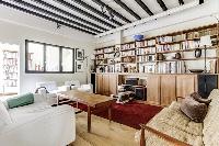 a lovely open living with a leather sofa, arm chairs, a centerpiece, a lovely carpet on a parquet fl