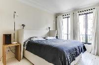 master bedroom with a king-size bed and a full en suite bathroom in a 4-bedroom Paris luxury apartme
