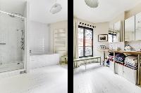 spacious well-maintained and neat bathroom with bathtub and washier and dryer in a 4-bedroom Paris l