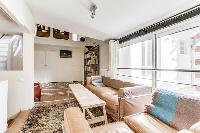 a lovely open living with a leather sofa, arm chairs, a centerpiece, a lovely carpet on a parquet fl