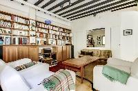 a lovely open living with a leather sofa, arm chairs, a centerpiece, a lovely carpet on a parquet fl