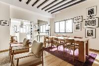 a lovely living and dining area with exposed wooden beams in a 4-bedroom Paris luxury apartment